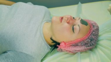 Zaman sukut. Makyajcısı adamın ellerini kadının yüzünde bir maske deniz yosunu koymak