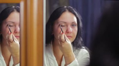 Beyaz önlük bir ayna önünde genç bir kadın makyaj göz