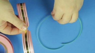 Pembe bir boş bir hediye yay için pembe kaplama ile kadın elim kolum bağlı. Mavi arka plan
