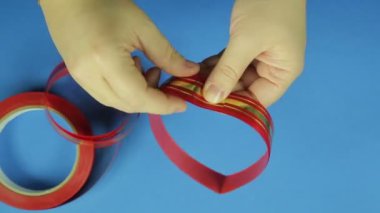 Kadın elleri boş bir kırmızı kurdele yay için kat. Mavi arka plan