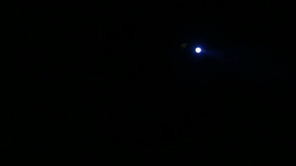 Луч синего света от профиля прожектора направленный на сцену в полной темноте — стоковое видео