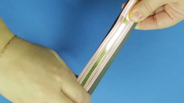 Kadın el pembe boş bir hediye yay için şablondan kaldırmak. Mavi arka plan