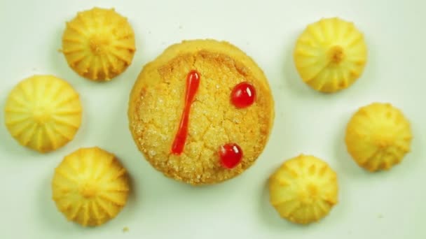 Galletas de mantequilla con pintura culinaria pintadas con un emoticono divertido y rodeadas de pequeñas galletas. Movimiento en círculo — Vídeo de stock