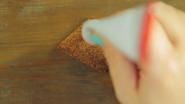 Uma mão segura um tubo de tinta culinária e desenha canecas engraçadas com tinta vermelha em biscoitos de chocolate — Vídeo de Stock