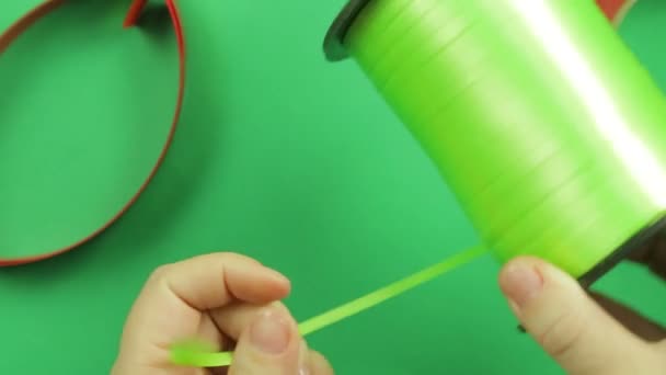 Woman scissors cut green ribbon on green background. — Stock Video