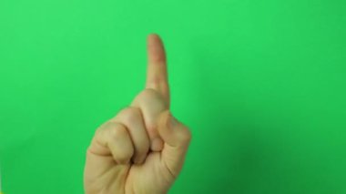 Yükseltilmiş bir işaret parmağı ile yeşil bir arka plan üzerinde erkek el.