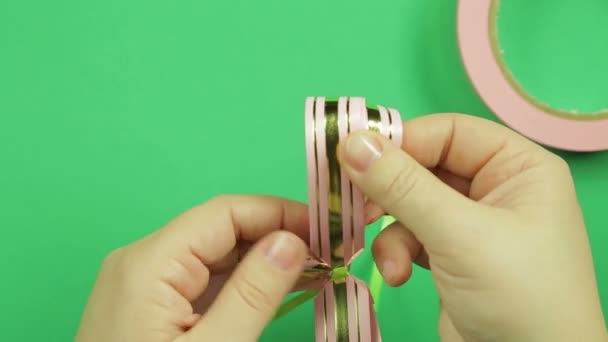 Female hands straighten the petals of the bow blank on a green background — Stock Video