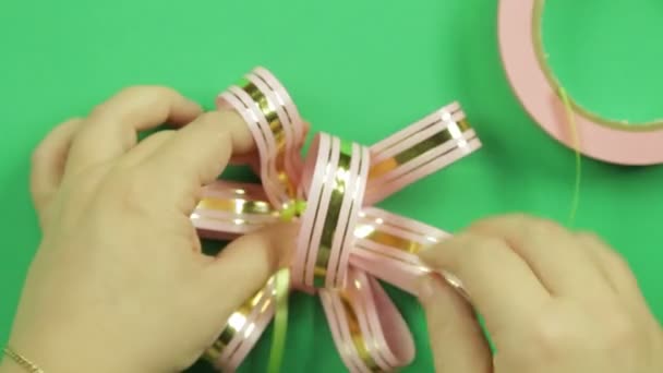 Подарунковий бант з рожевої стрічки на зеленому фоні — стокове відео