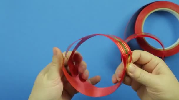 青色の背景に赤いリボンのギフト弓を作る。時間周 — ストック動画