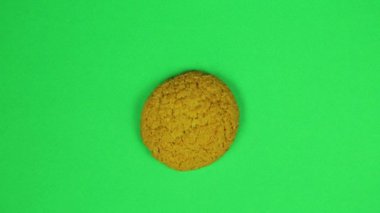 Çocuk yen oturum çerezleri üzerine yeşil renkli kahverengi krema üzerine çizer. Zaman sukut.