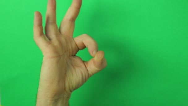 Manlig hand på en grön bakgrund visar en gest ok. Närbild — Stockvideo