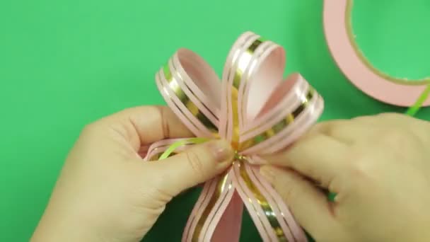 Female Hands Give Shape Pink Ribbon Bow Green Background Handmade — Stock Video