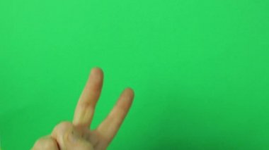 Yükseltilmiş bir işaret parmağı ile yeşil bir arka plan üzerinde erkek el.