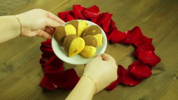 Flickan sätter en platta av cookies i mitten av hjärtat. — Stockvideo
