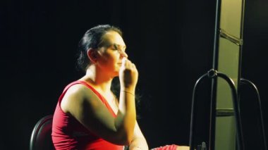 Genç kadın aynanın önünde kaşlarını şekiller.