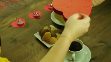 Kafede genç insanlar birbirlerine mum ışığında hediyeler vermek.