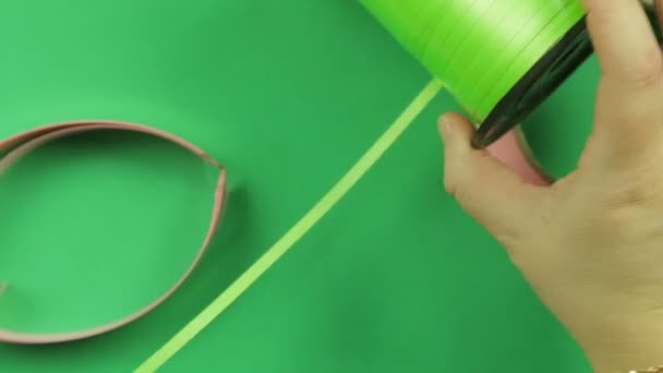 Woman scissors cut green ribbon on green background. — Stock Video