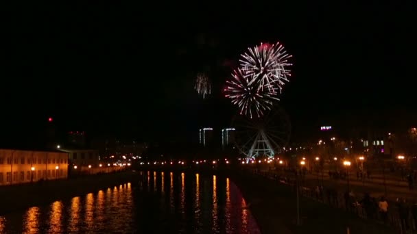 Fogos de artifício brilhantes na cidade no dique no céu noturno refletido no rio — Vídeo de Stock