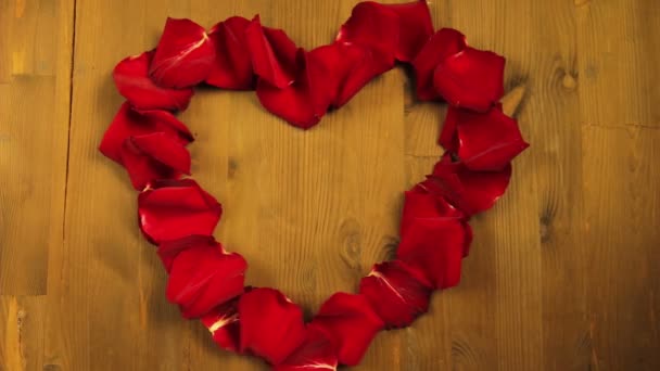 La fille met au milieu du cœur des biscuits aux pétales de rose dans une assiette blanche — Video