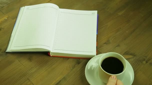 Flickan skriver ordet kärlek i dagboken och dricker kaffe. Tid varv — Stockvideo
