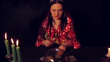 Çingene falcı mum ışığında masada fortunetelling kartları yayılır.