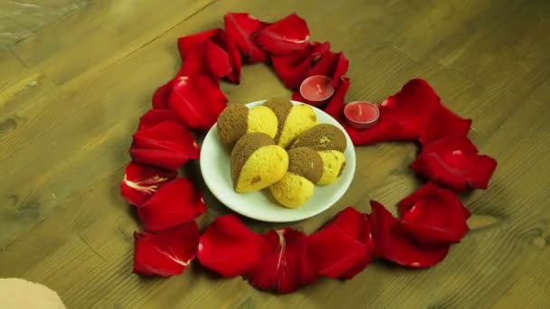 Дівчина кладе тарілку печива посеред серця — стокове відео