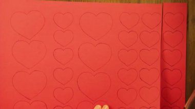 Kız kırmızı karton kalpleri ile boş keser. Zaman sukut