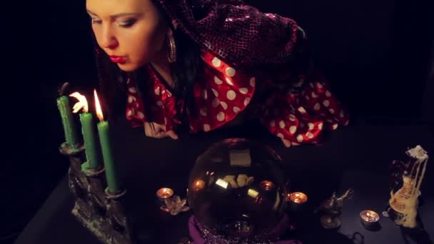 Gypsy fortune-teller blows out the candles after divination. — Stock Video