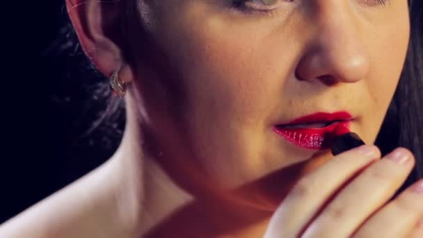Kvinnlig hand målar läpparna på ansiktet med klarröda läppstift. — Stockvideo