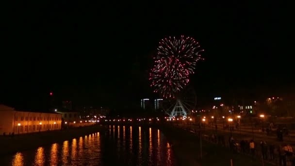 明亮美丽的烟花在城市的堤防上的夜空的背景下 摩天轮反映在河里 总体规划 — 图库视频影像