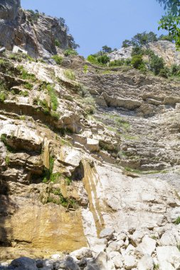 Yüksek dağlar yeşil bitki örtüsü ile kaplı. Kavrulmuş şelale.