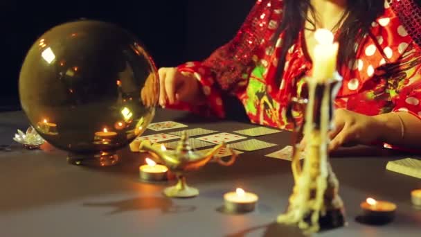 Цыган в предсказательном салуне при свечах раздает карты для гадания на столе — стоковое видео