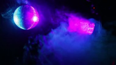 Projektör ışınları yanardöner puf duman farklı renklerde siyah bir zemin üzerine ayna disko topu