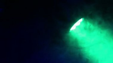 Bir bulut duman otomobillerin çok renkli ışınları yayan bir projektör. Siyah arka plan