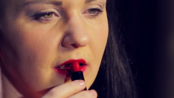 Kvinnlig hand målar läpparna med klarröda läppstift. Närbild — Stockvideo