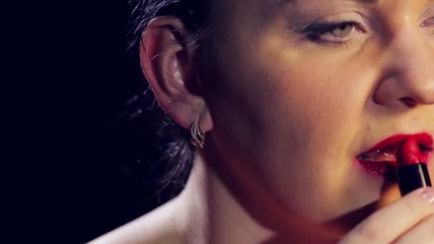 La mano femminile dipinge labbra con rossetto rosso vivo. Primo piano — Video Stock