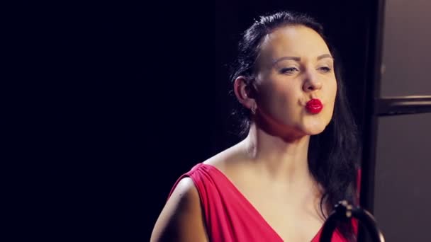 Giovane donna in abito rosso con rossetto rosso sorride. Primo piano — Video Stock