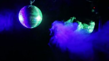 Projektör ışınları yanardöner puf duman farklı renklerde siyah bir zemin üzerine ayna disko topu