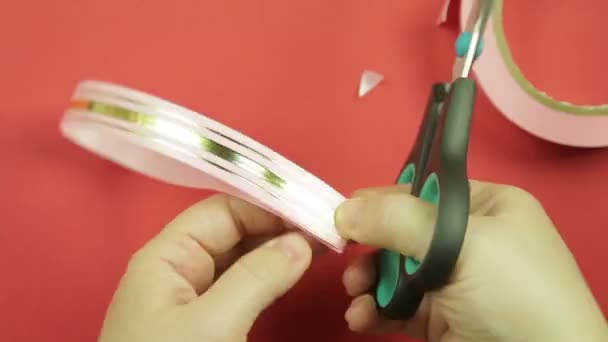 Making a gift bow of pink ribbon on a red background. Time laps — Stock Video