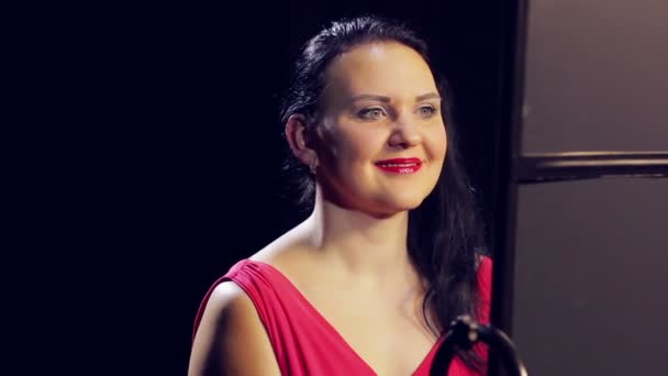 Young woman in red dress with red lipstick is smiling. Close-up — Stock Video