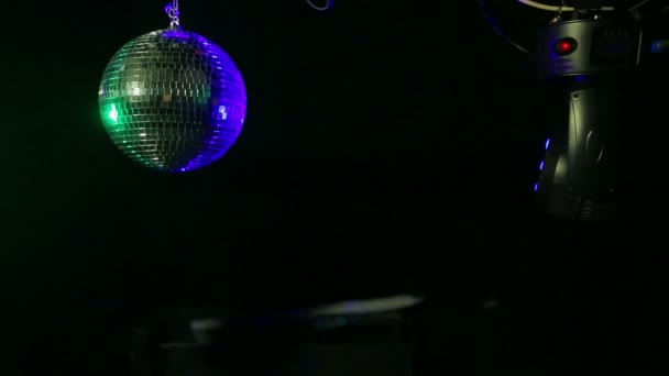 Zrcadlová disko koule na černém pozadí s nosníky modré a zelené searchlight zaměřené na jeho — Stock video
