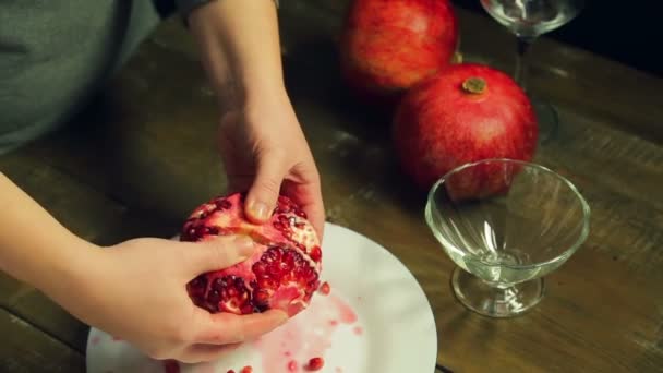 Vrouw breekt gepelde subsidie op een witte plaat op een houten tafel — Stockvideo