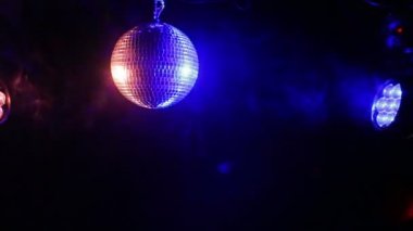 Projektör ışığı mavi, yeşil ve kırmızı duman siyah bir zemin üzerine ayna disko topu.