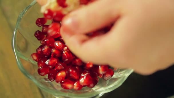 Una donna separa i grani di melograno in un vaso di vetro . — Video Stock