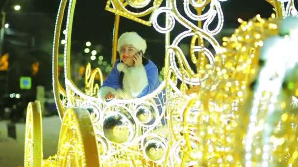 A smiling snow maiden is talking on the phone and waving a greeting out of the carriage window in greeting — Stock Video