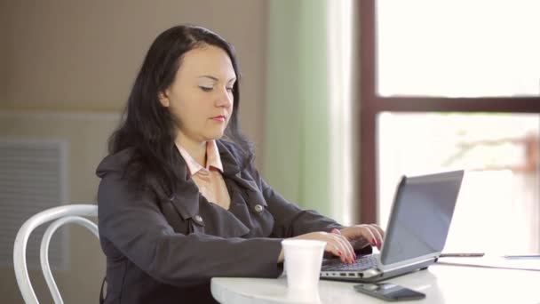 穿着深色夹克在笔记本电脑上工作 喝咖啡的年轻女子 缓慢的莫 中间的计划 — 图库视频影像