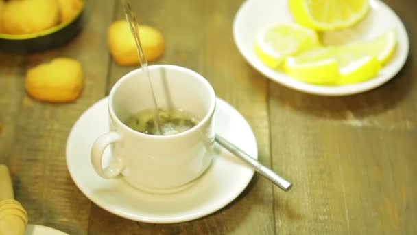 Un chorro de agua hirviendo se vierte en una taza de hojas de té. El plan medio — Vídeo de stock