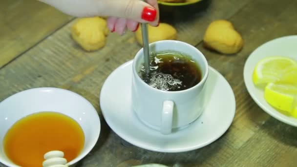 Woman stir in spoon in white cup on wooden table. Freshly brewed black tea — Stock Video