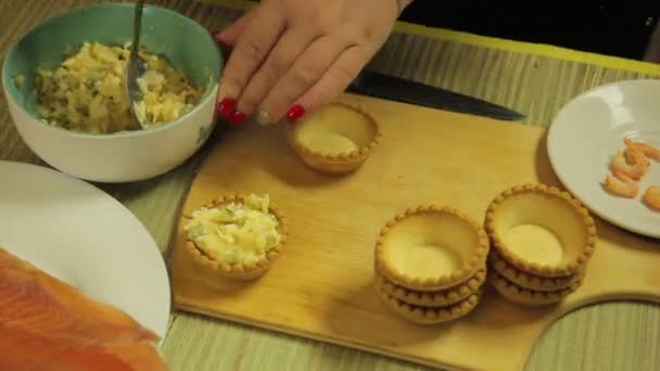 Female hand puts salad in tartlets on wooden board. Time laps — Stock Footage Female hand puts salad in tartlets on wooden board. Time laps Royalty Free Stock Video