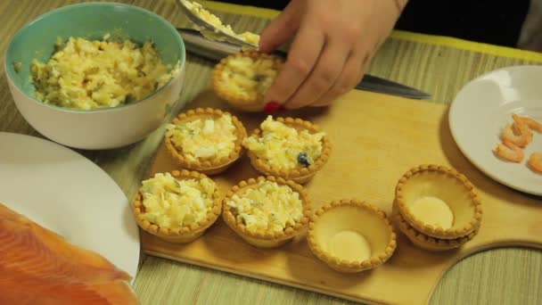 A woman puts tartlets on a salad. The average plan — Stock Video